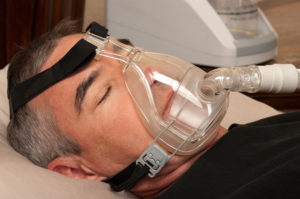 Man with sleeping apnea and CPAP machine